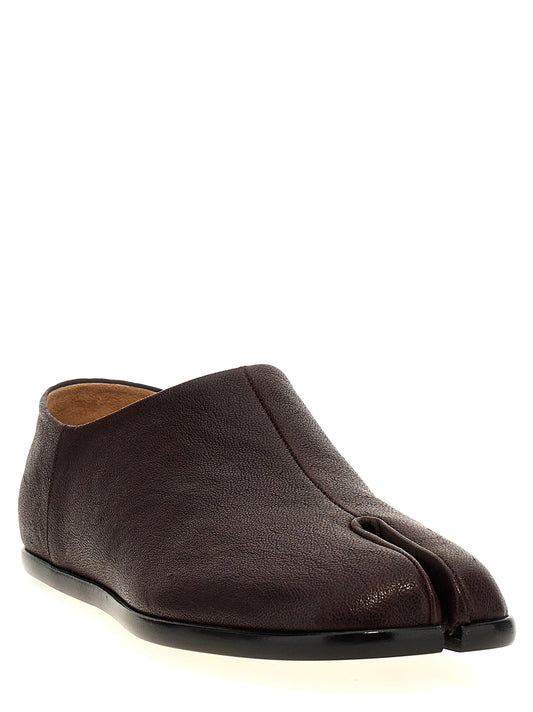 A dark brown split-toe slip-on shoe with a textured leather upper and a black sole, shown from a three-quarters angle on a white background.